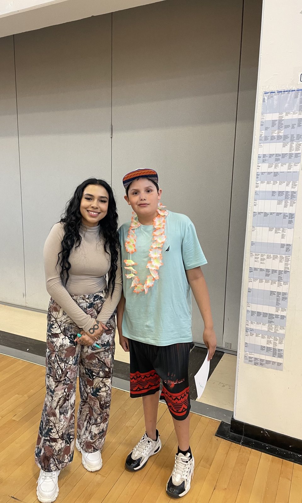 Stella Standingbear with a young fan in a school gymnasium